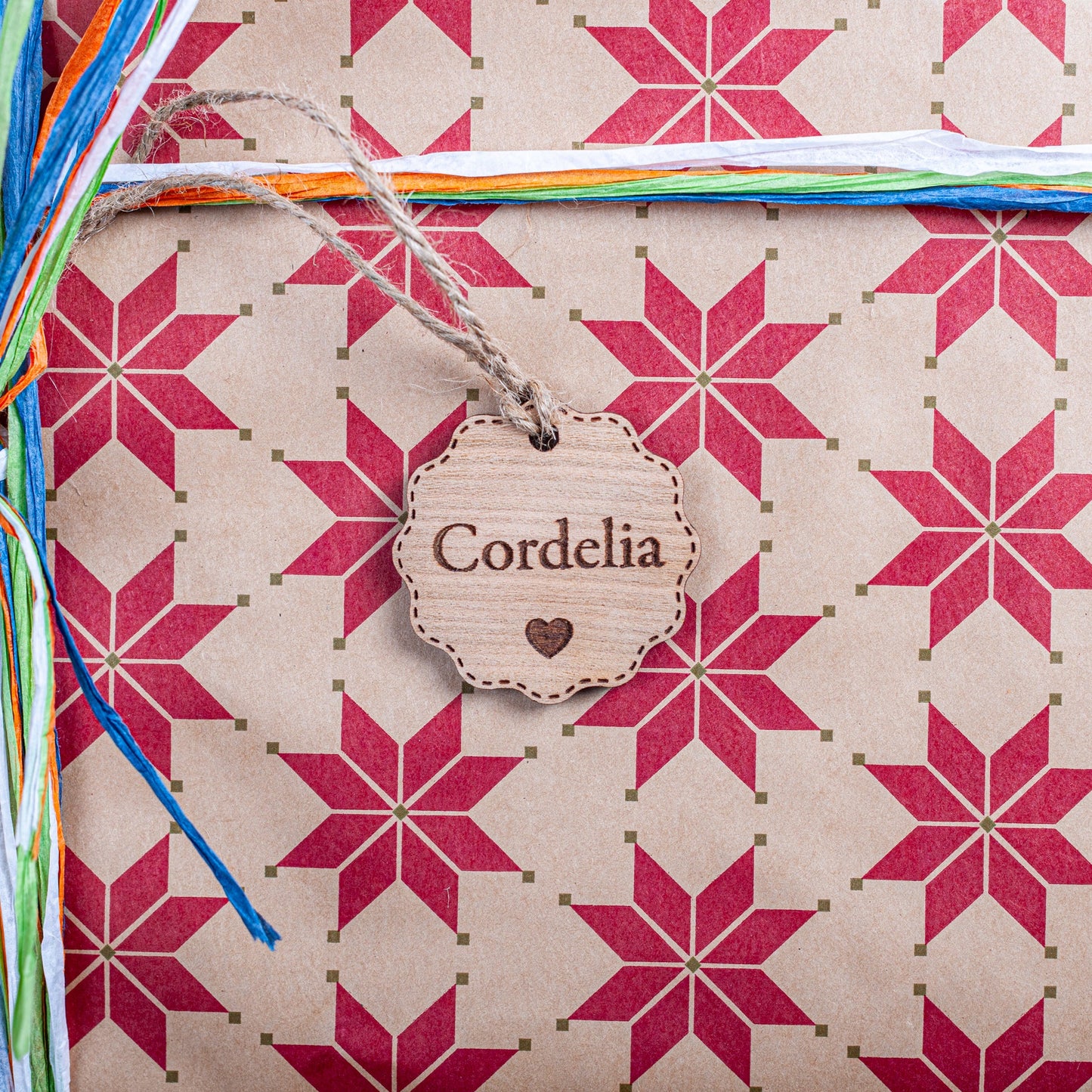 Gift with star pattern, colorful ribbons, and a name tag.