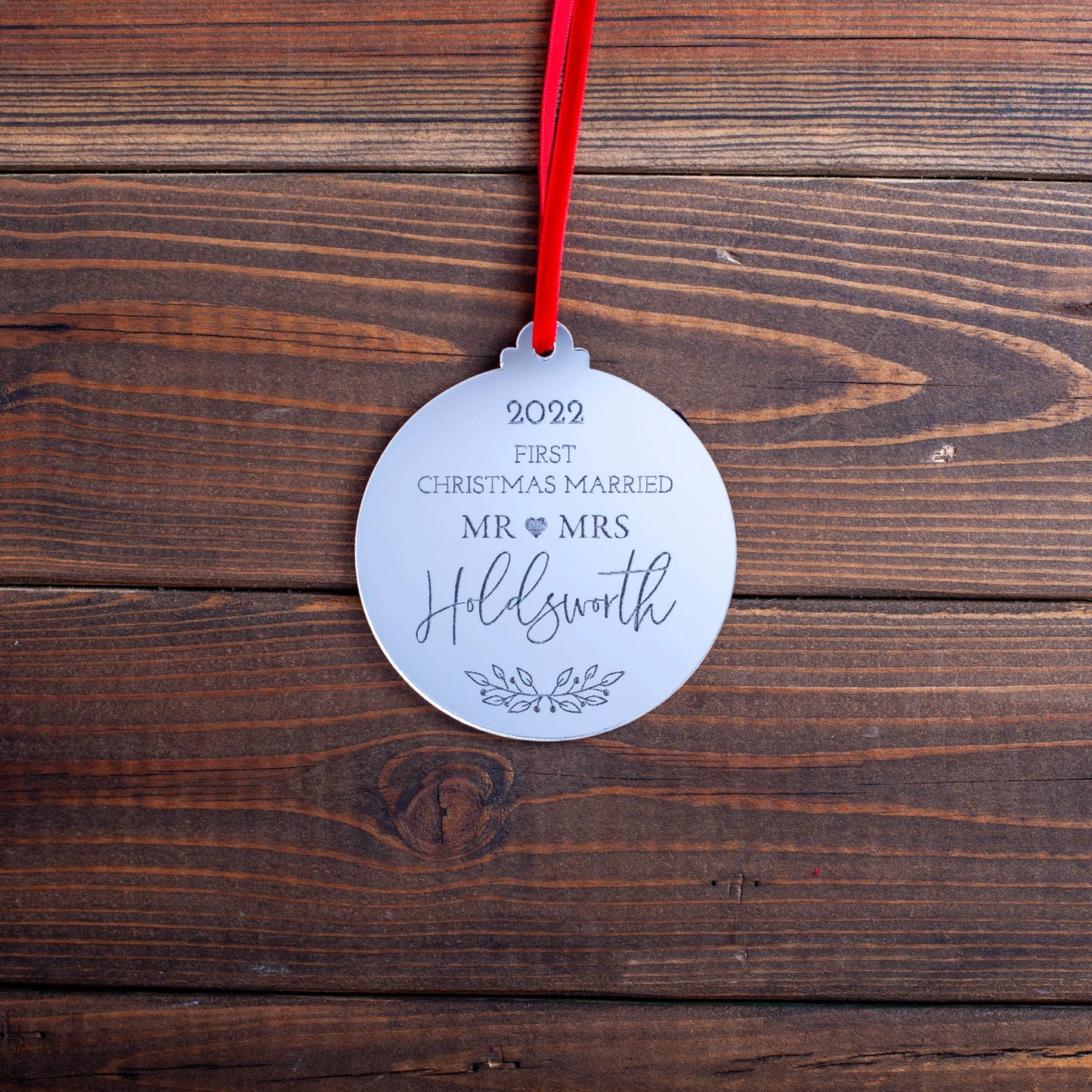 Mirror acrylic bauble engraved with “Our First Christmas Married”