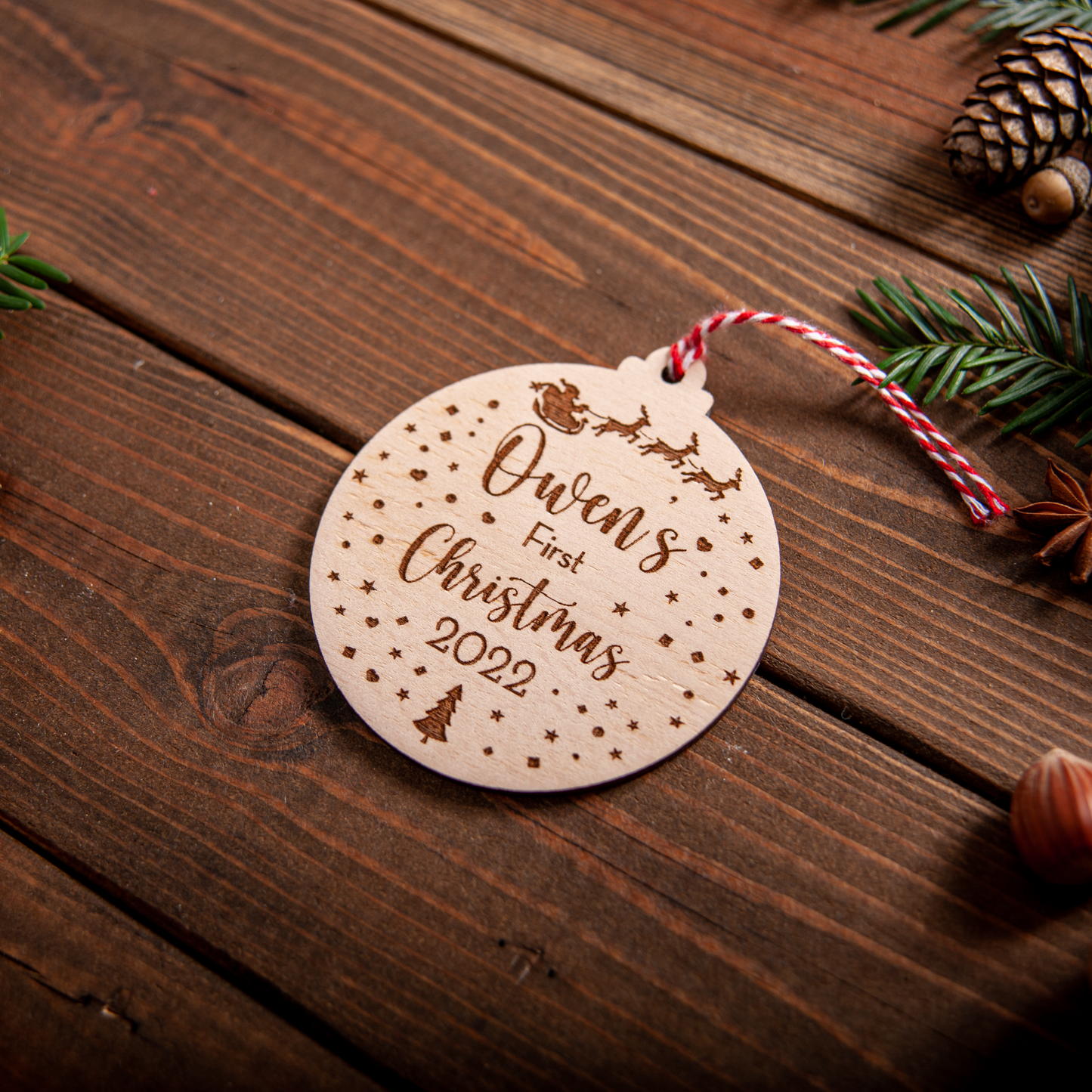 Wooden snow-globe baby name bauble with engraved details