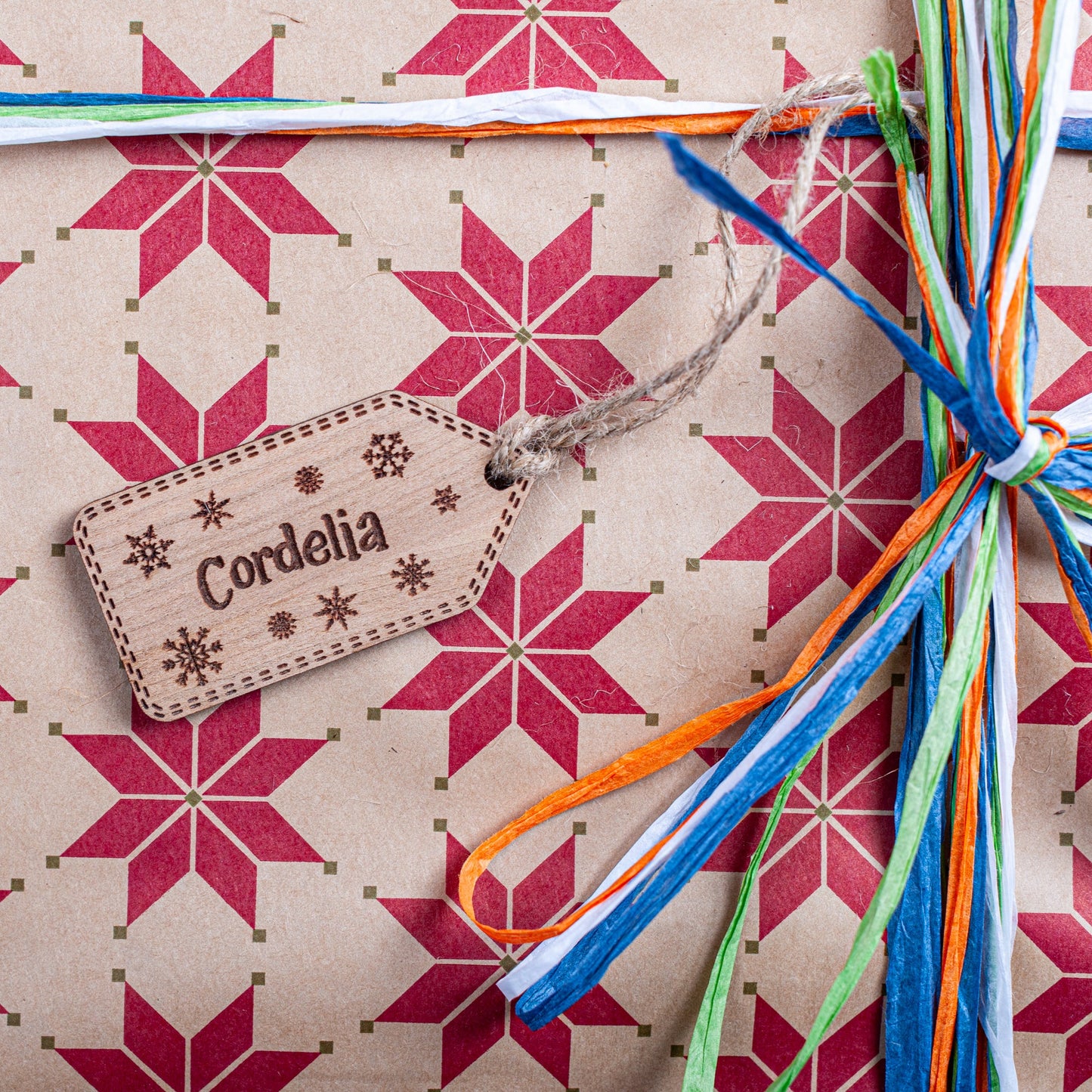 Gift with star pattern, colorful ribbons, and a custom christmas name tag on a matching background