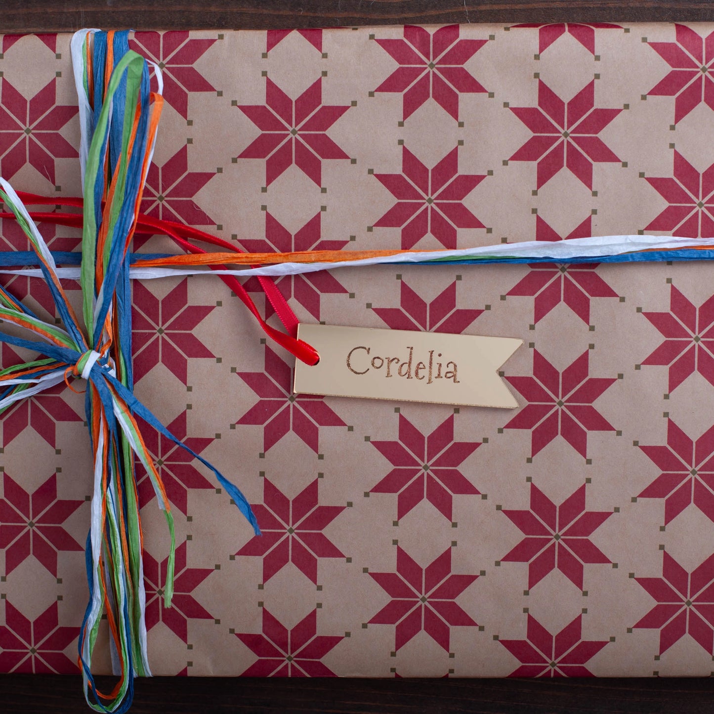 Elegant personalised gold mirror tag on wrapped Christmas gift box