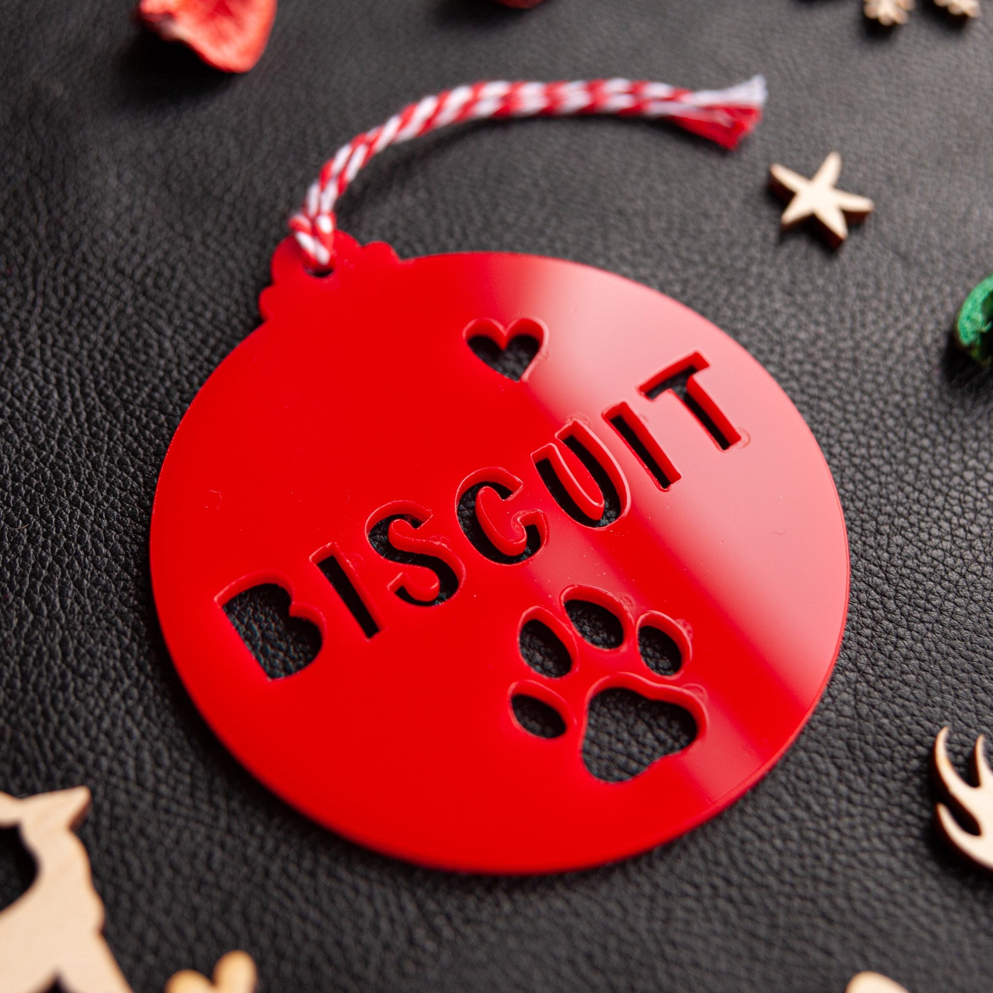 Personalised red acrylic pet name bauble hanging on tree