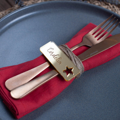 Engraved rectangular Christmas place card featuring custom guest name and star cutout detail