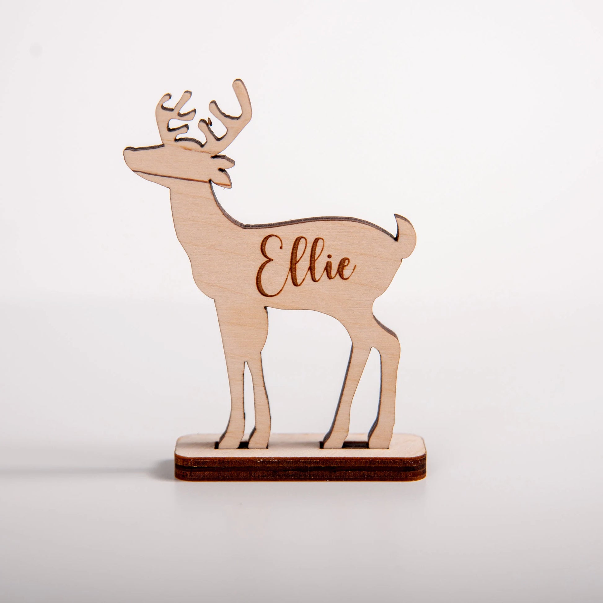 Wooden deer figurine with name engraved on a white background