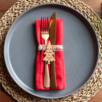 Close-up of engraved Christmas tree place card with custom guest name