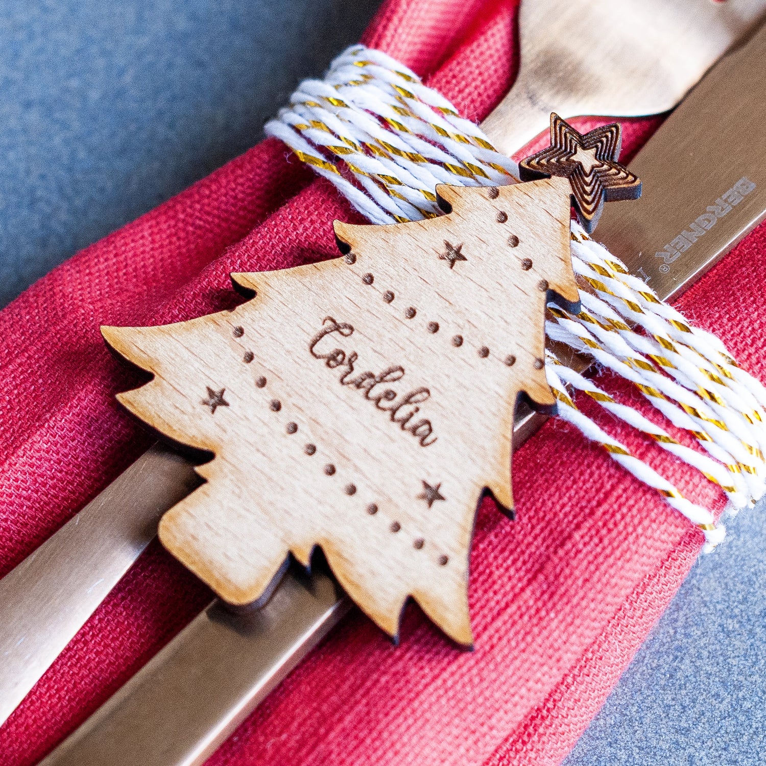 Wooden Christmas tree place name with name engraving on a red napkin.