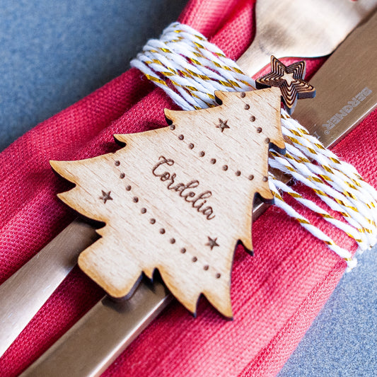 Wooden Christmas tree place name with name engraving on a red napkin.