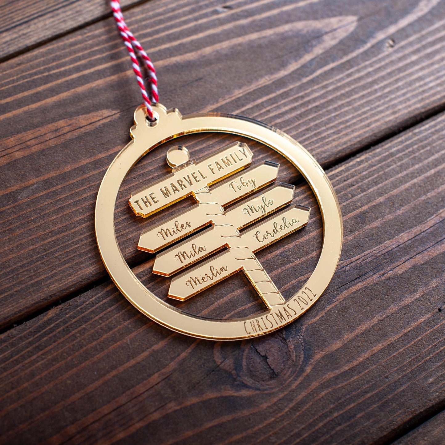 Gold mirror family Christmas bauble with laser-cut names on North Pole design