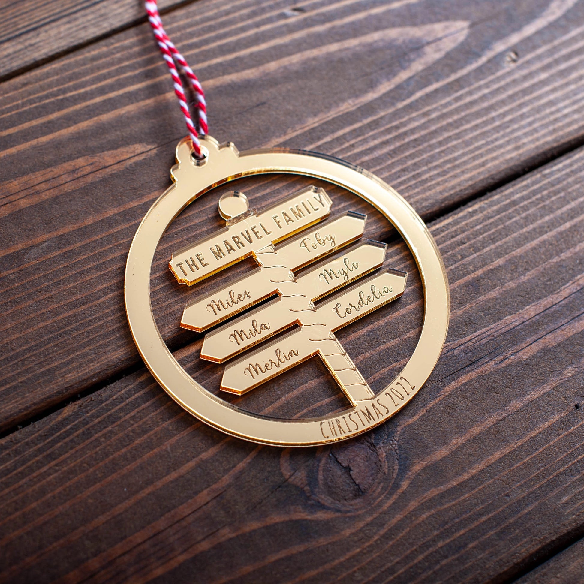Gold mirror family Christmas bauble with laser-cut names on North Pole design