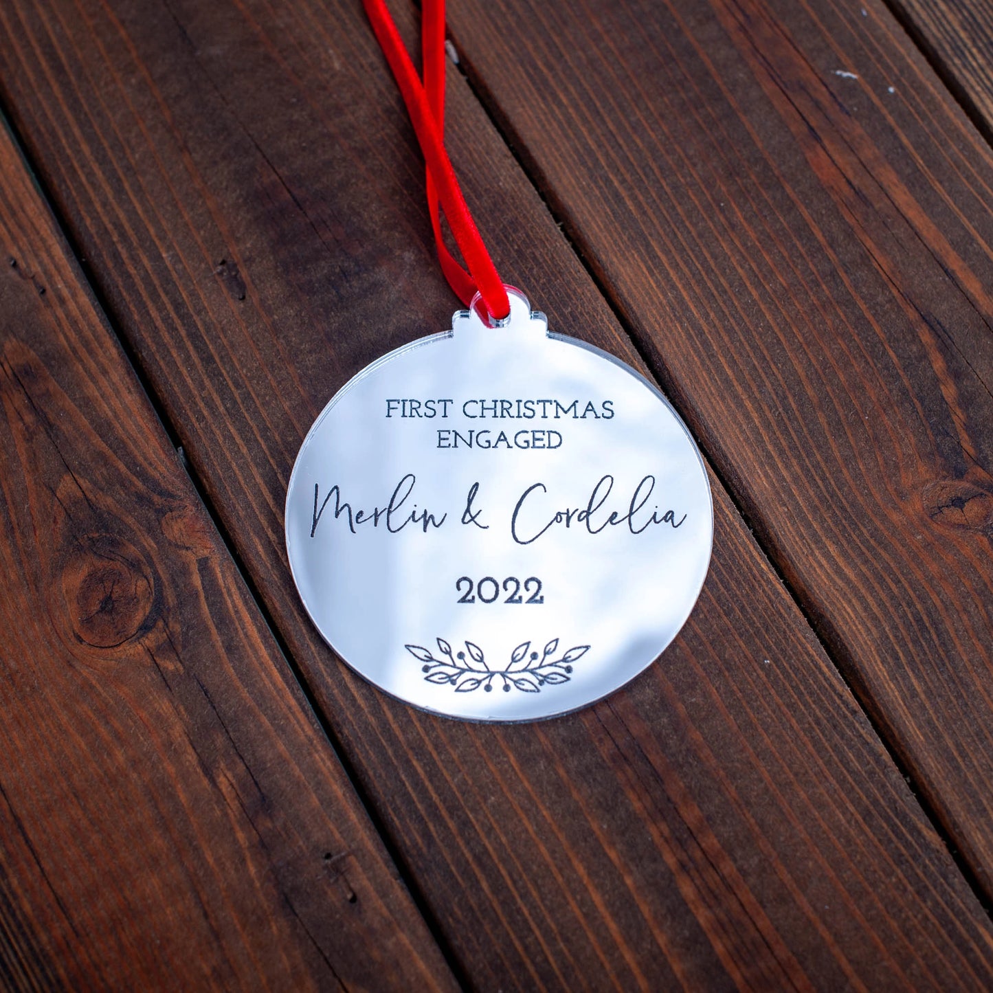 Silver mirror ornament engraved with engaged couple’s names and year