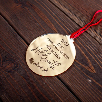 Personalised gold mirror bauble hanging on Christmas tree with engraved names