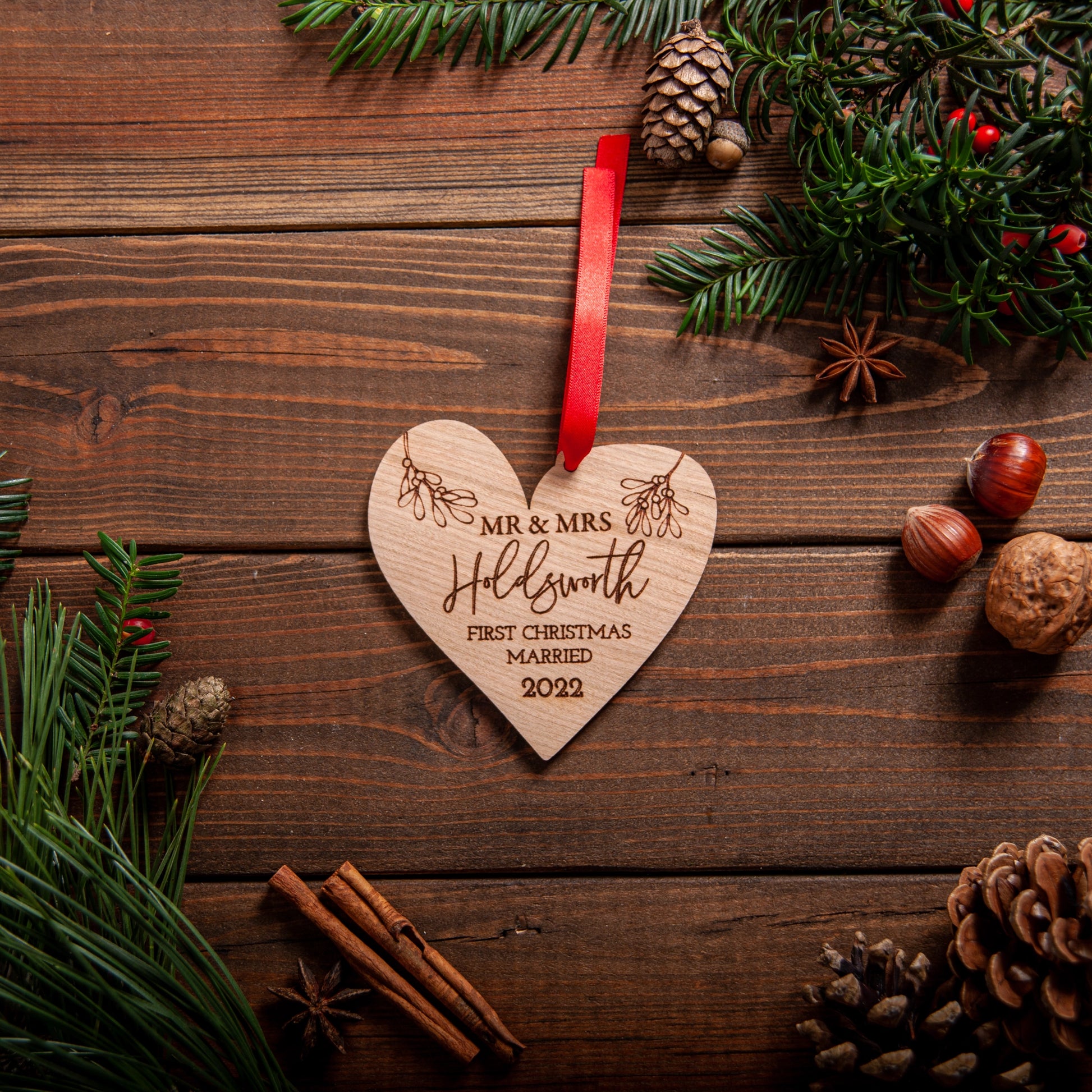 Personalised heart-shaped Christmas ornament for newlyweds with engraved names and ribbon