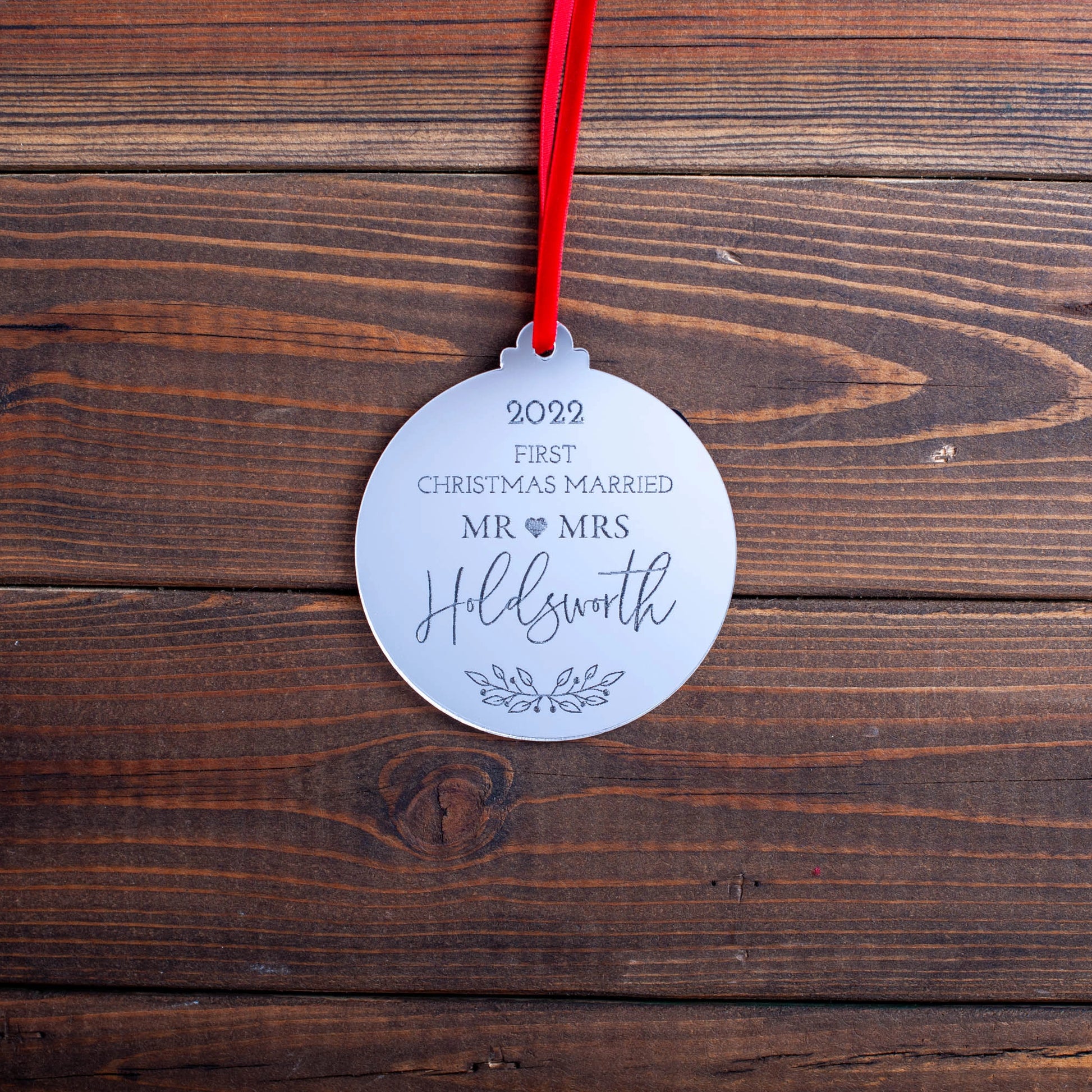 Mirror acrylic bauble engraved with “Our First Christmas Married”