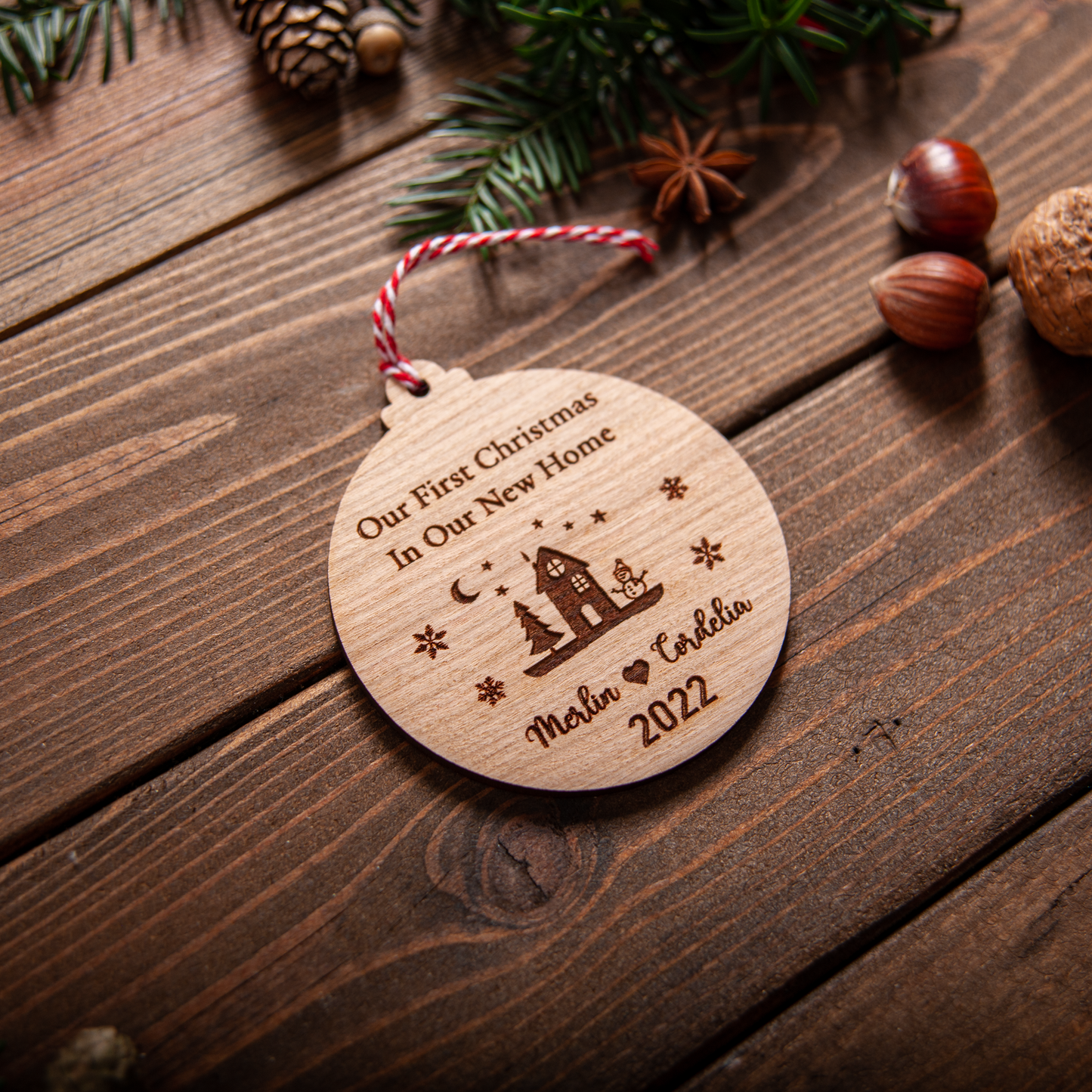 Engraved new house bauble with ribbon hanging on Christmas tree