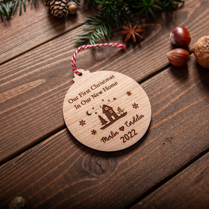 Engraved new house bauble with ribbon hanging on Christmas tree