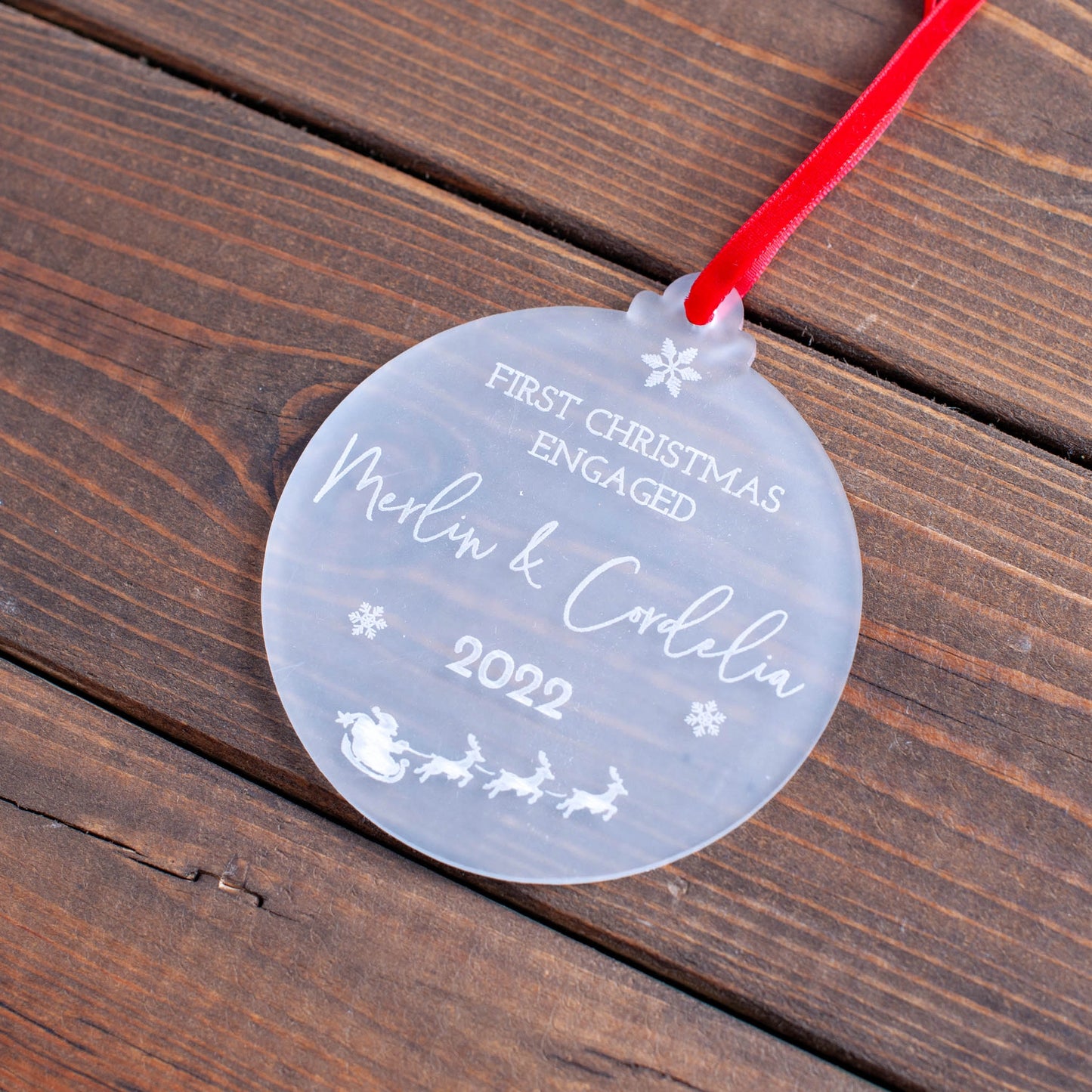 Elegant first Christmas engaged ornament hanging on festive tree