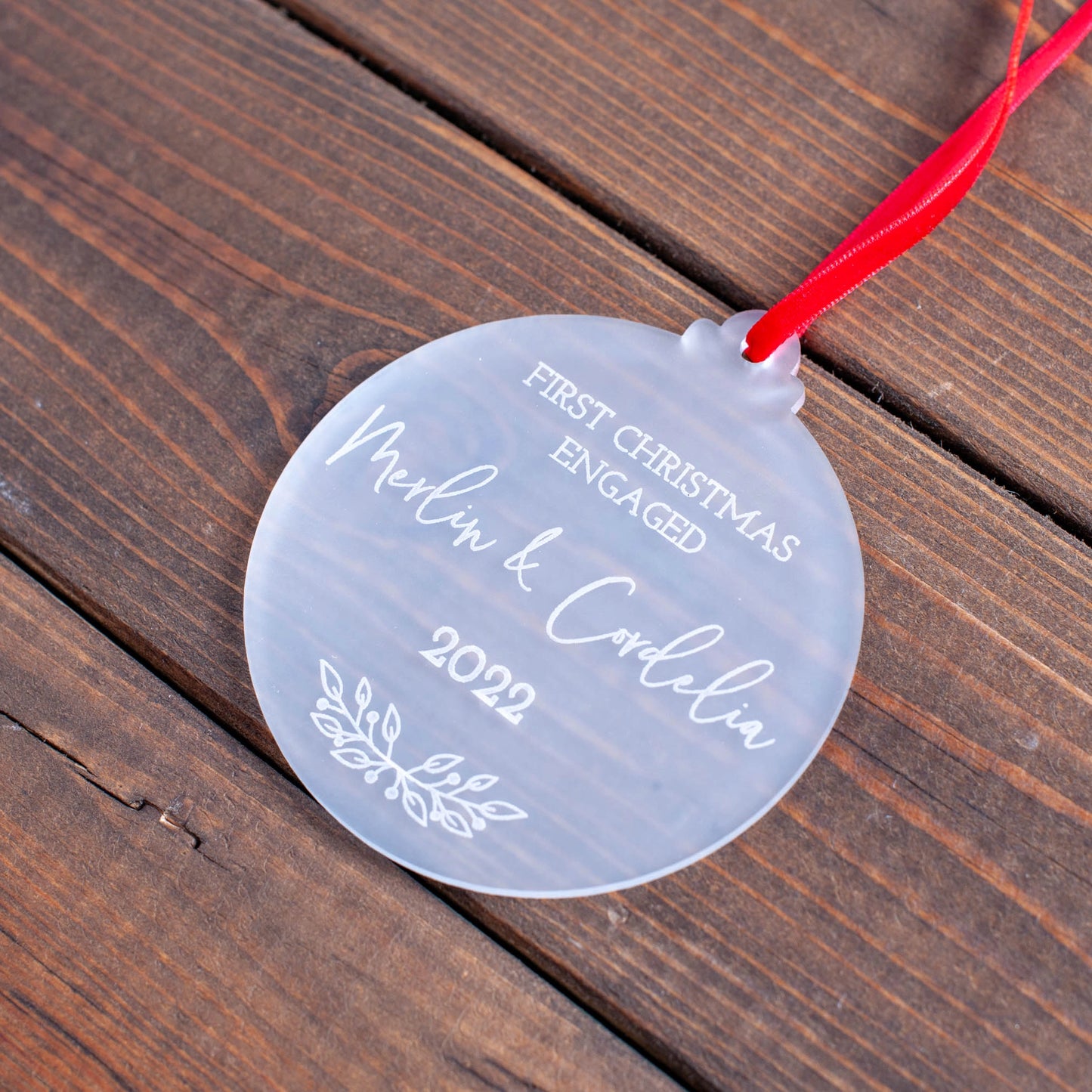 Frosted ornament engraved for newly engaged couple with ribbon