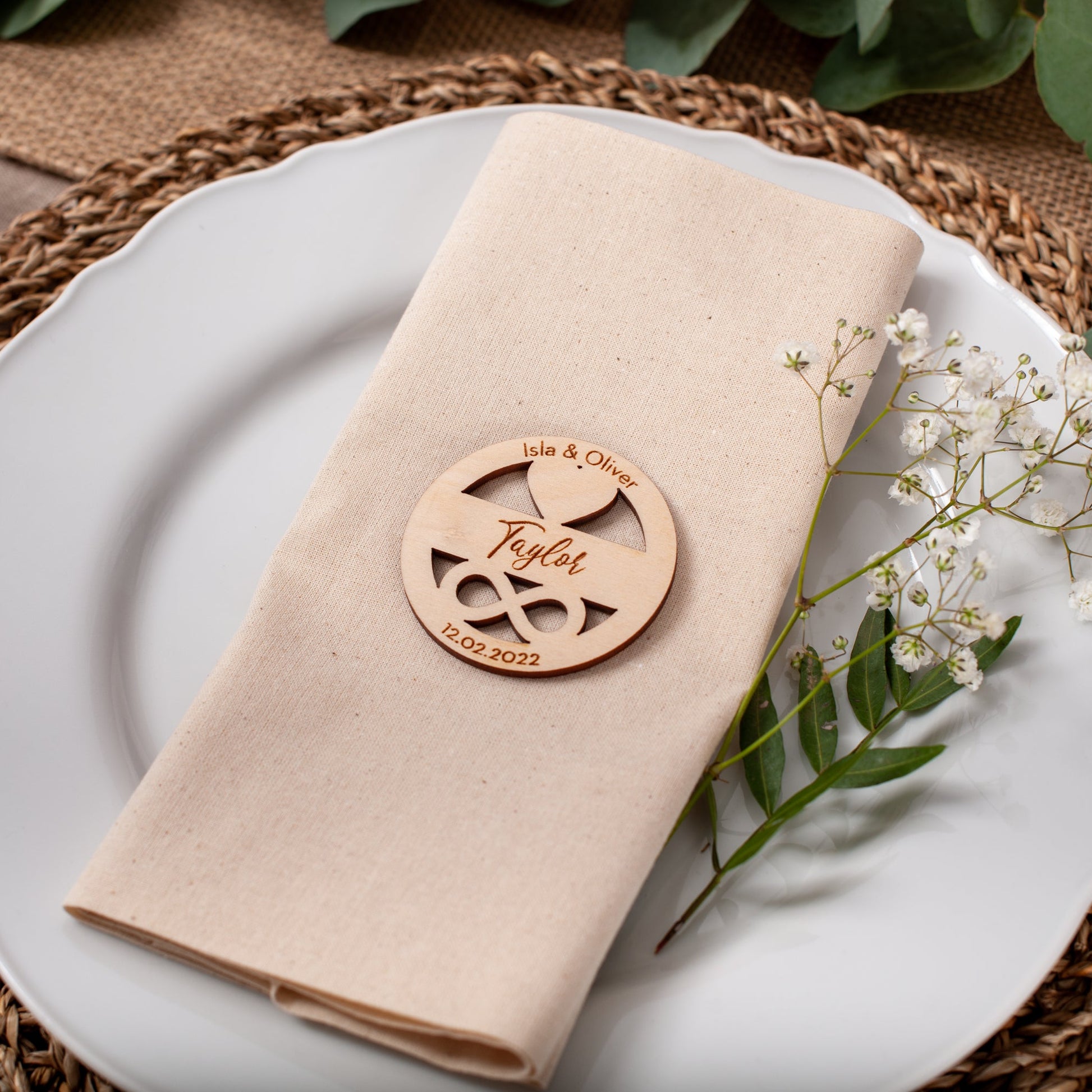 Napkin with personalized wooden name tag on a white plate with a decorative setting