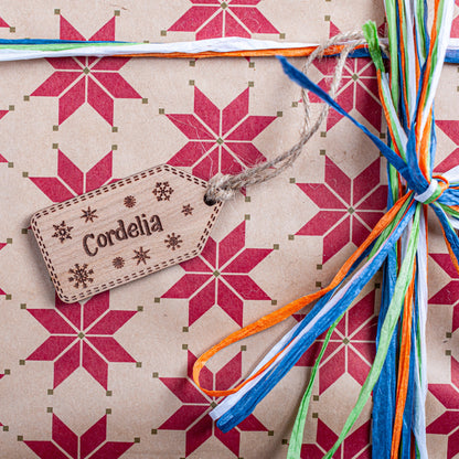Gift with star pattern, colorful ribbons, and a custom christmas name tag on a matching background