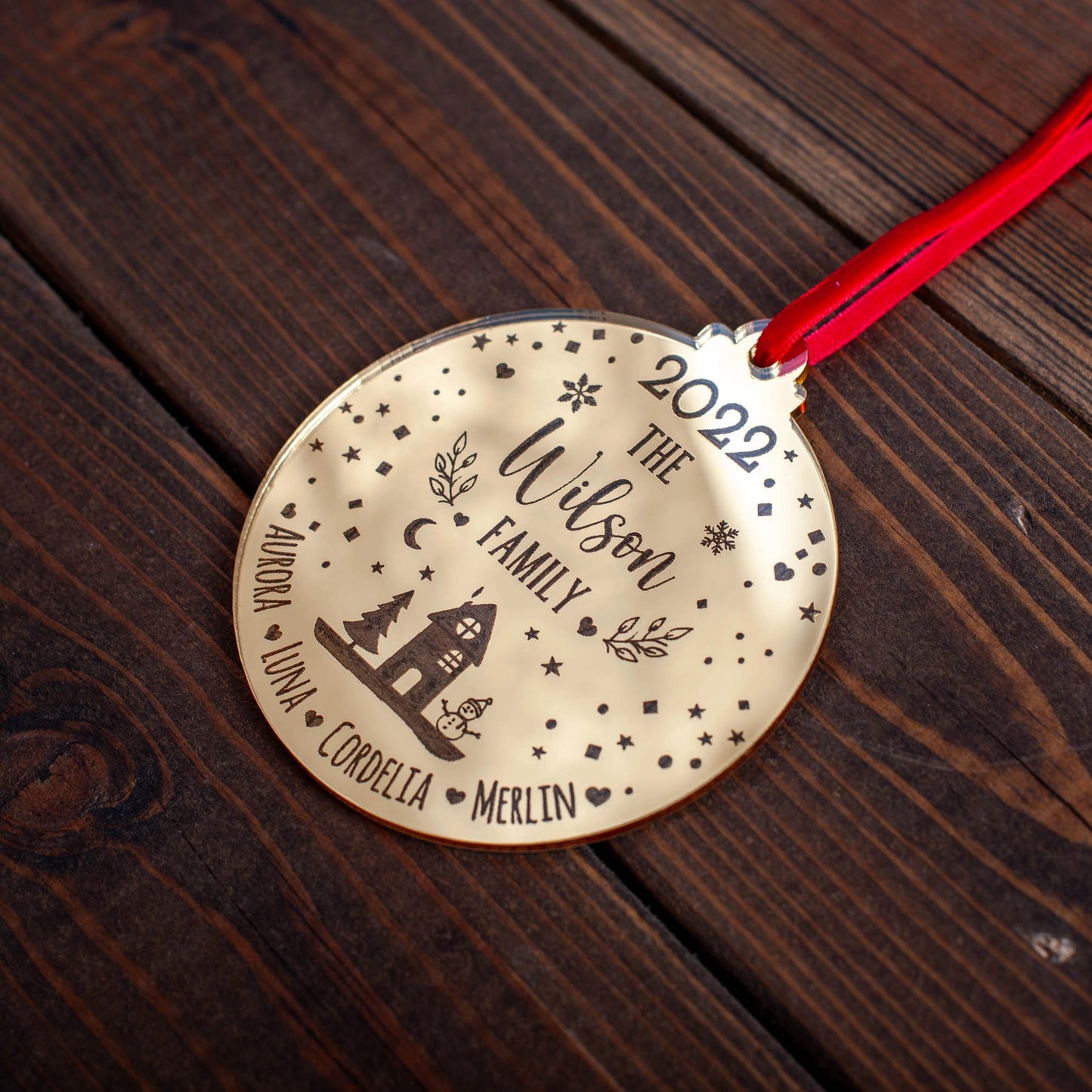 Personalised family Christmas bauble hanging on tree branch