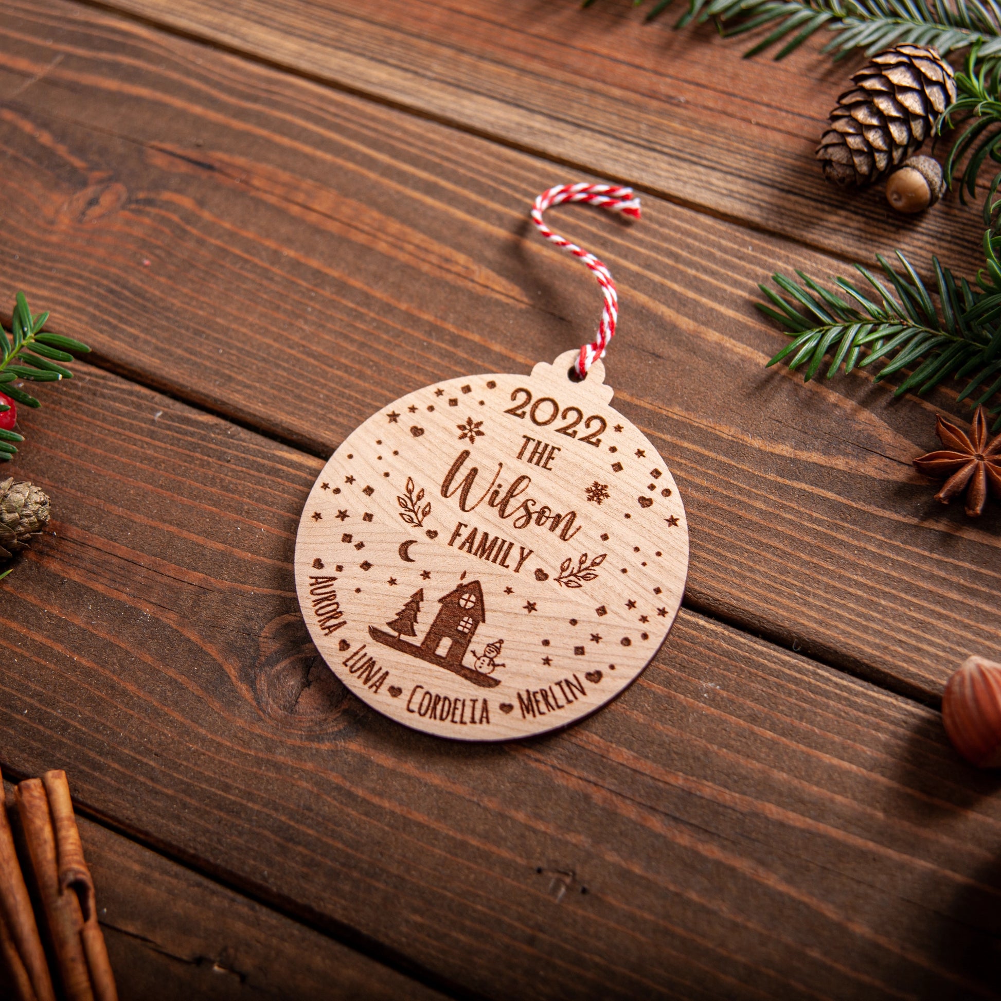 Engraved wooden snowglobe ornament with family name and year