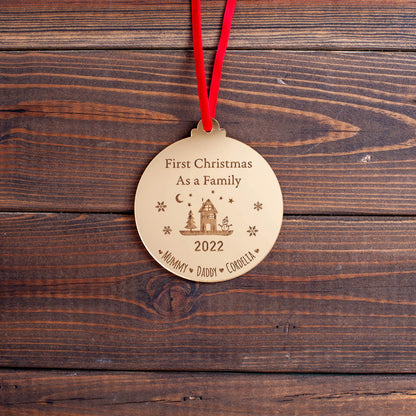 Elegant gold acrylic family bauble hanging on tree branch