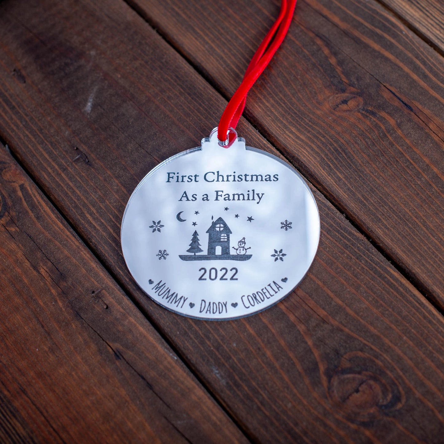 Silver mirror family ornament reflecting Christmas lights