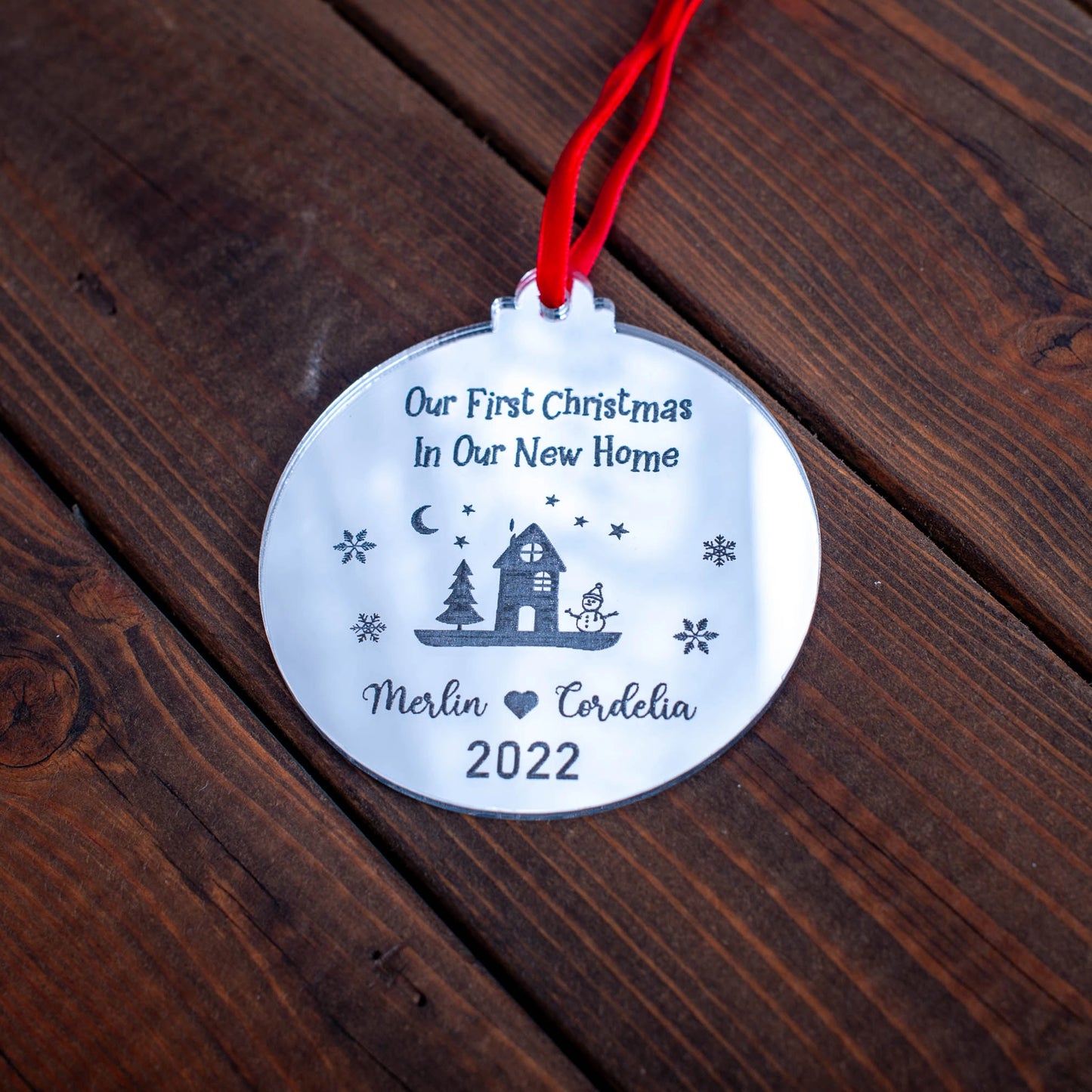 Silver mirror Christmas bauble engraved with “First Christmas in Our New Home” and year