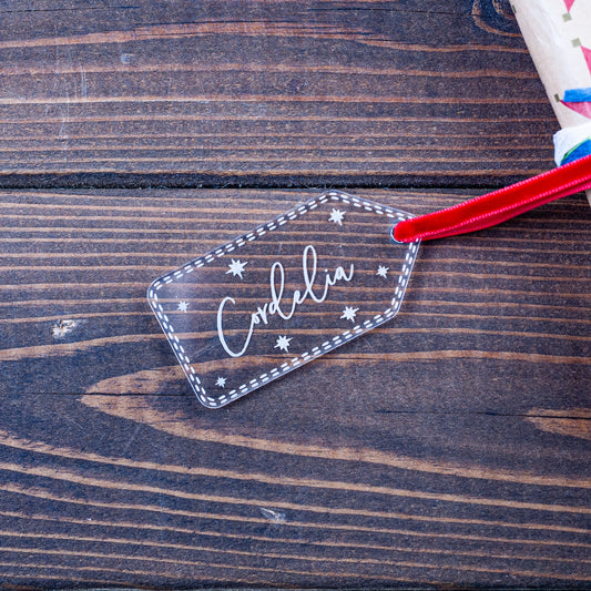 Clear acrylic Christmas gift tag engraved with stars and name