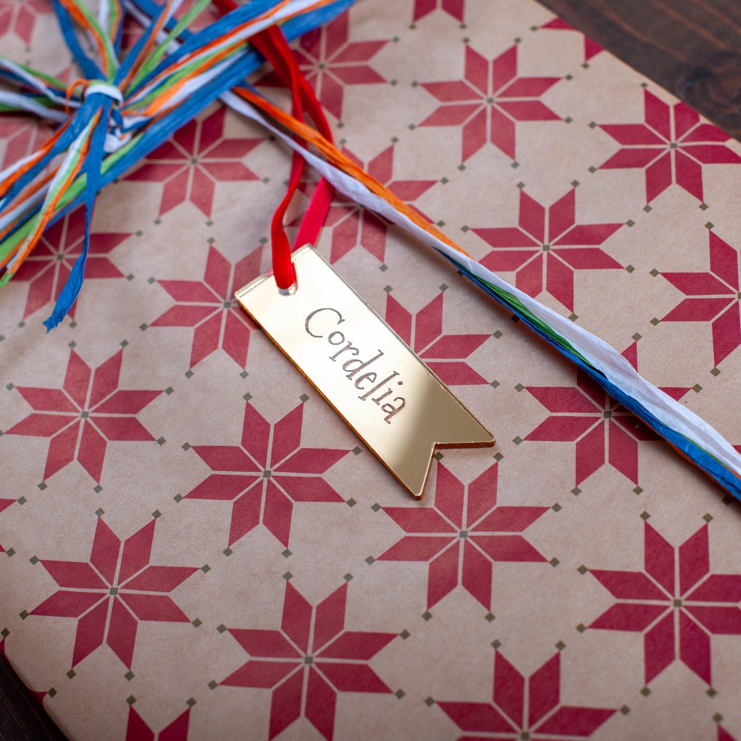 Custom engraved gold mirror acrylic tag with festive ribbon