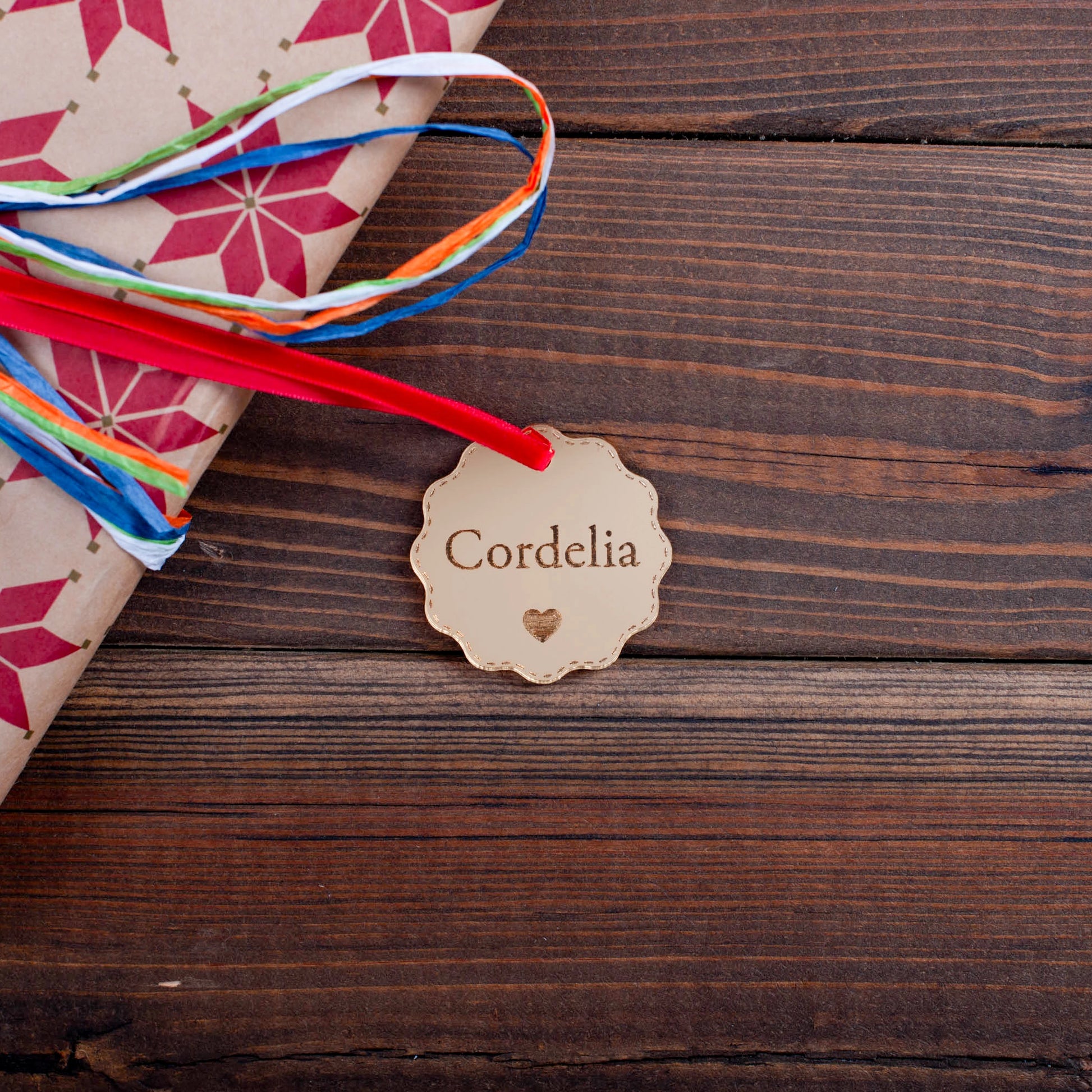 Personalised gold mirror acrylic bauble tag on wrapped Christmas gift