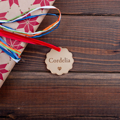 Personalised gold mirror acrylic bauble tag on wrapped Christmas gift