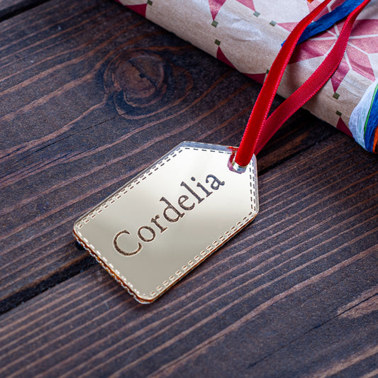 Custom gold mirror gift tag reflecting festive lights
