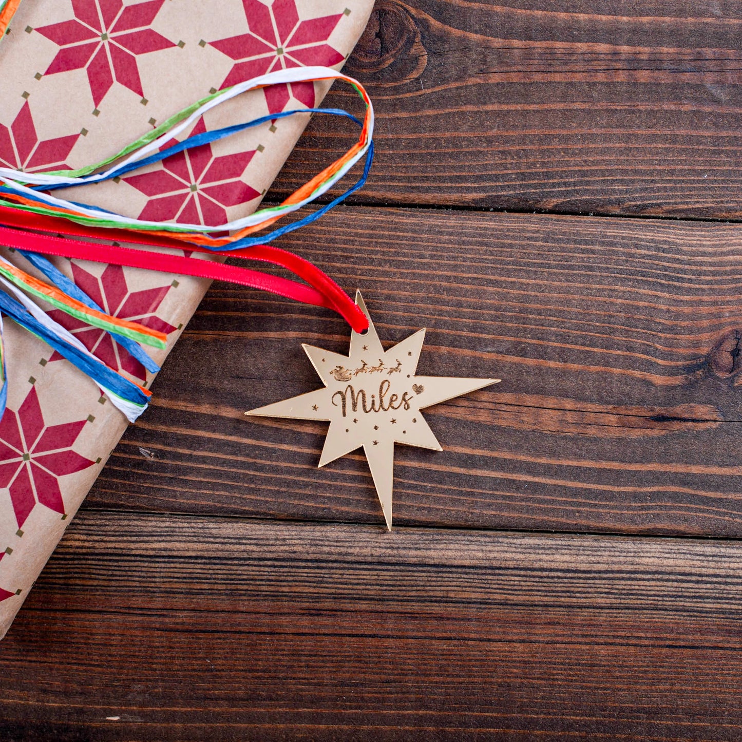 Engraved gold mirror star tag on festive wrapped gift