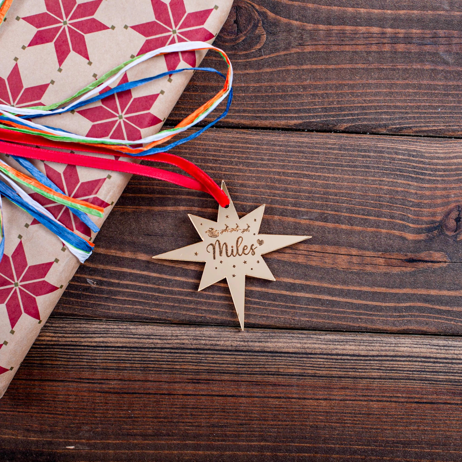 Engraved gold mirror star tag on festive wrapped gift