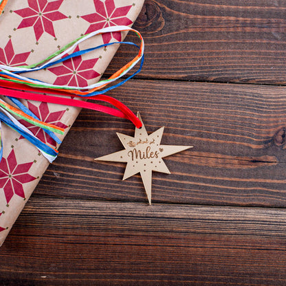 Engraved gold mirror star tag on festive wrapped gift