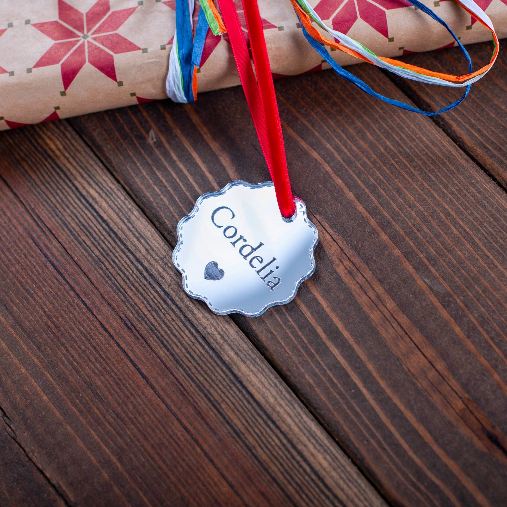 Custom engraved silver mirror bauble tag on wrapped Christmas gift