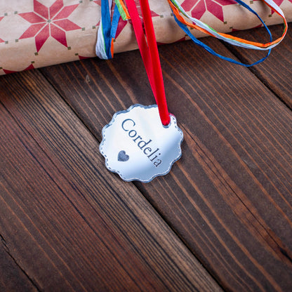 Custom engraved silver mirror bauble tag on wrapped Christmas gift