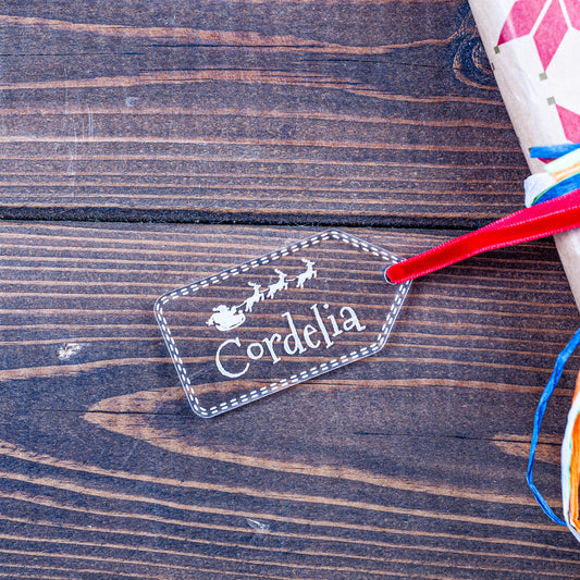 Clear acrylic Christmas gift tag with engraved Santa and sleigh design