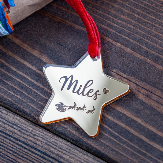 Gold mirror star-shaped Christmas gift tag engraved with Santa and sleigh