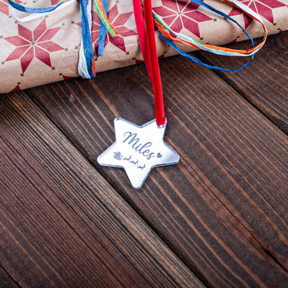 Engraved silver mirror star tag on wrapped Christmas present