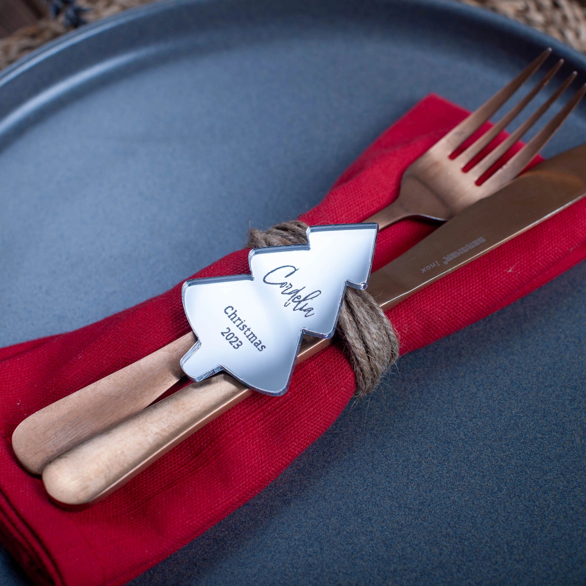 Laser-cut silver mirror Christmas tree ornament used as place setting