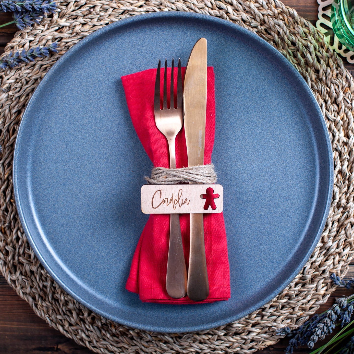 Wooden engraved place settings photographed flat with holly leaves and ornaments