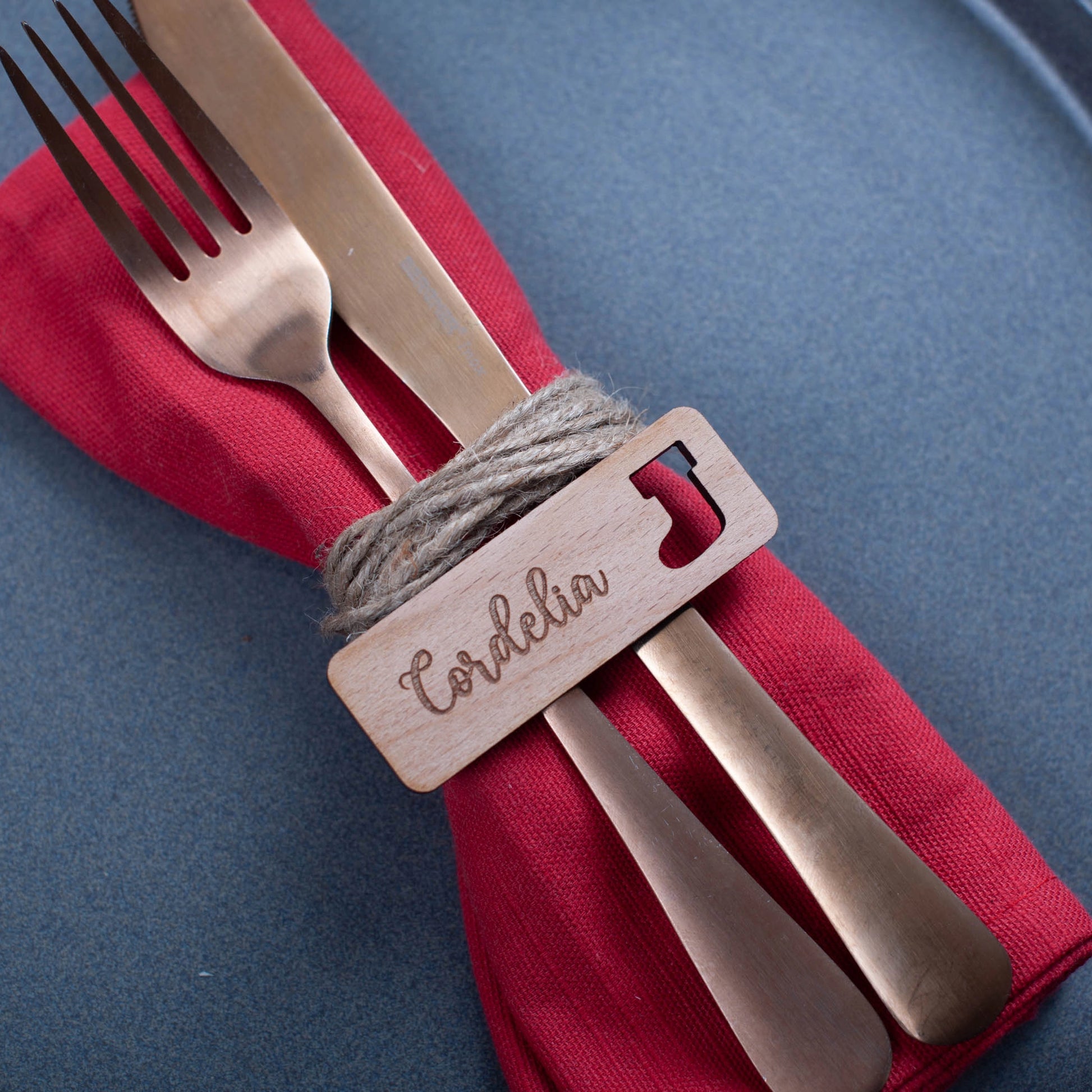 Festive place card in natural wood engraved with guest name and cutouts