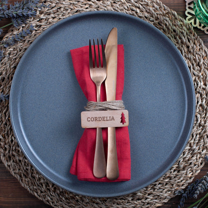 Flat-lay photo of natural wood Christmas place settings with christmas tree cutout