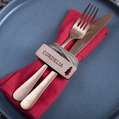 Flat-lay of personalised wooden Christmas table décor with festive christmas tree cutout