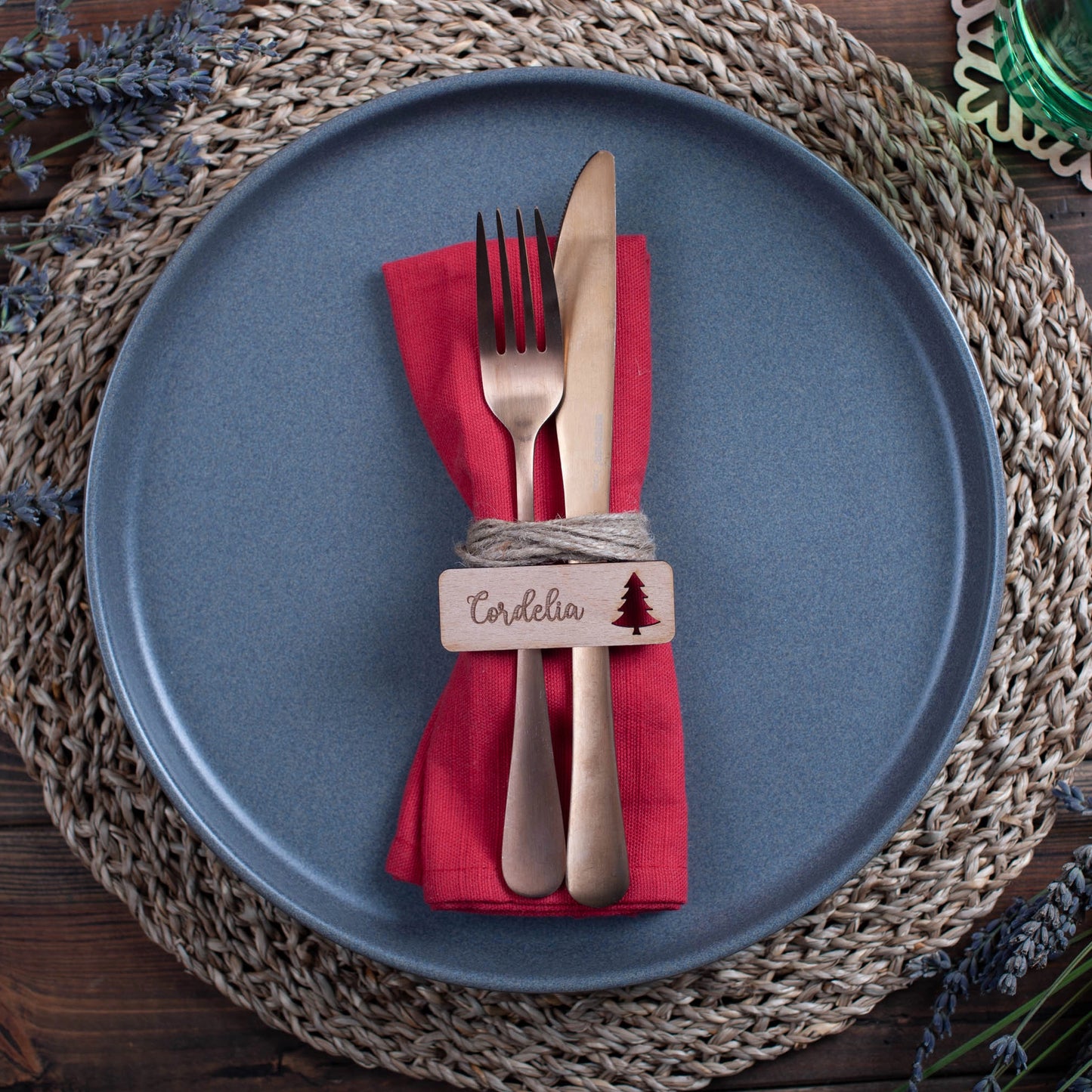 Wooden name tags with ornament cutouts arranged flat on Christmas table runner