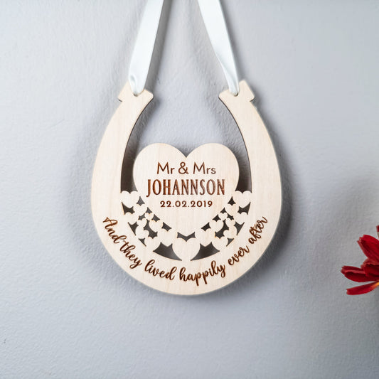 Personalized wooden horseshoe decoration with engraved text on a light gray background.
