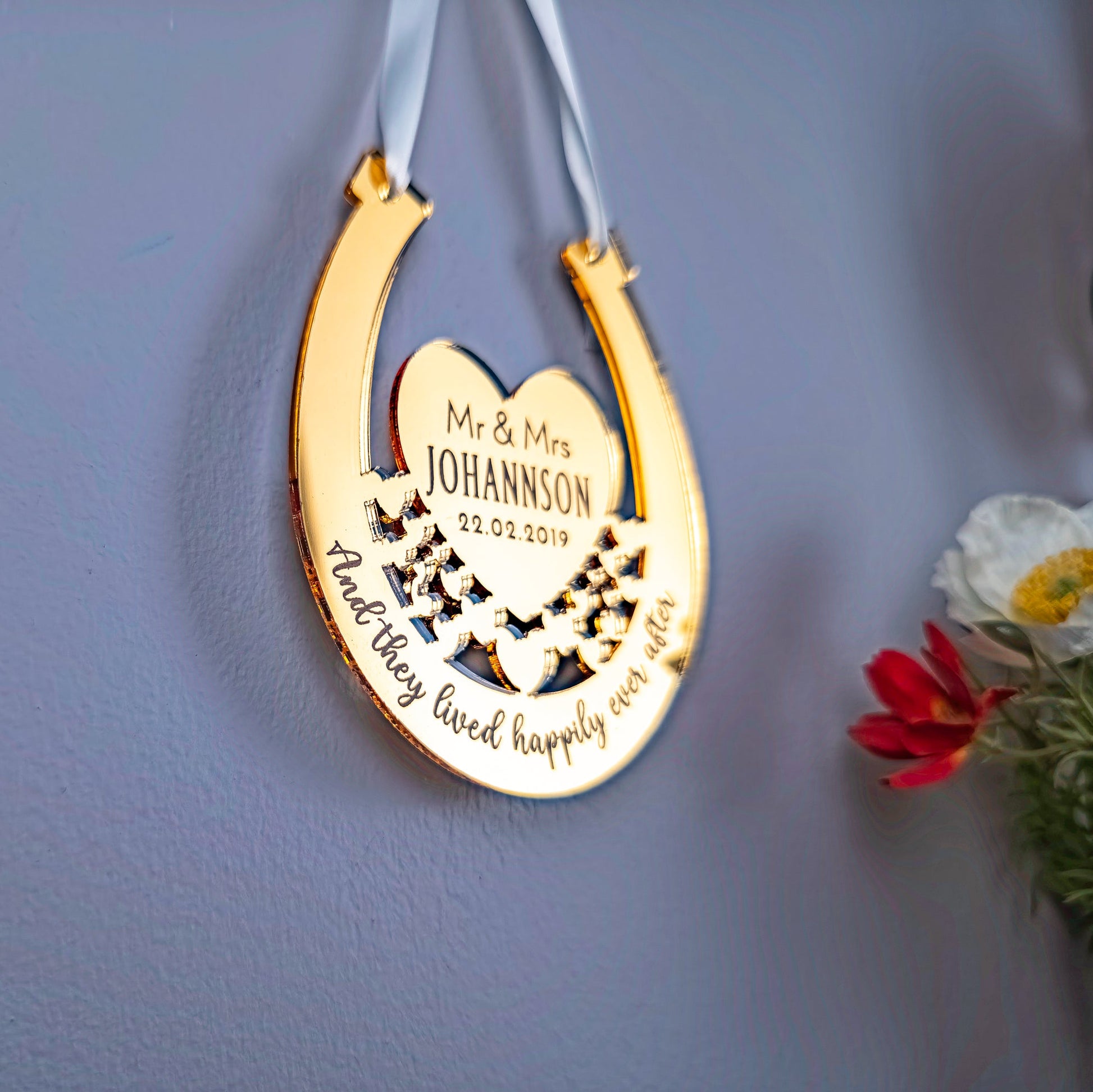 Decorative gold horseshoe with engraved text on a blue wall.