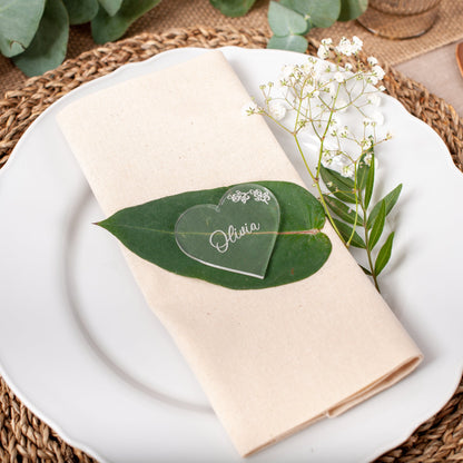 Plated dish with a green leaf and heart-shaped card on a woven placemat.